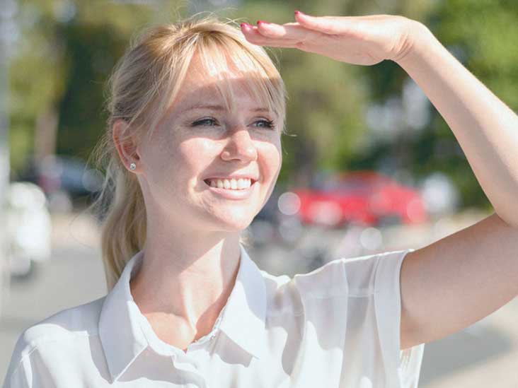 Young Woman shielding eyes from the direct sun