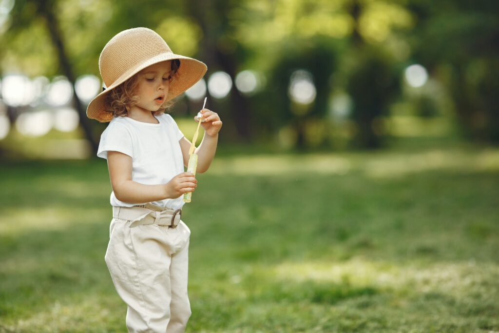 Young child dressed in sun blocking clothing.